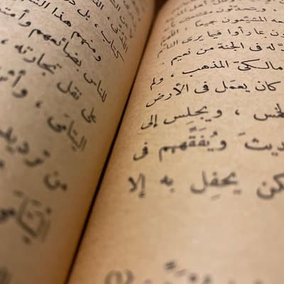 Closeup text from page of an Arabic book tilted to the right
